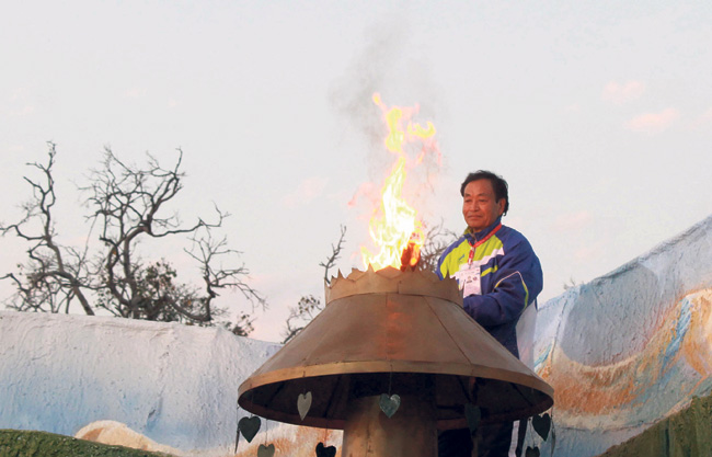 Former Olympian Narendra Poma lighting the Olympic torch.
